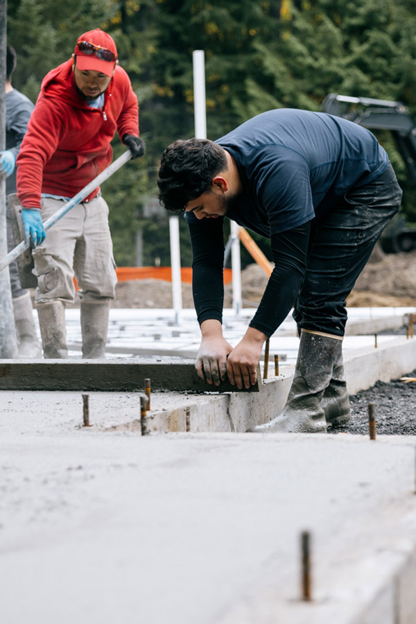 Crew finishing a poured concrete foundation on Long Island