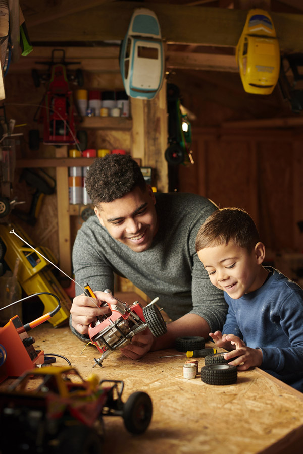 Father and son working on a project in a home garage workshop
