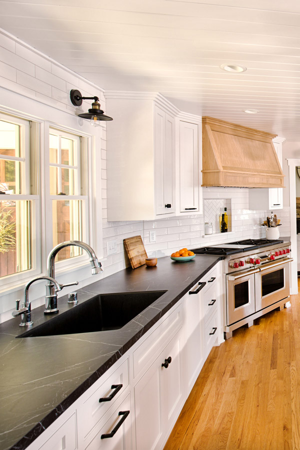 Renovated white kitchen with dark counters in a Long Island home