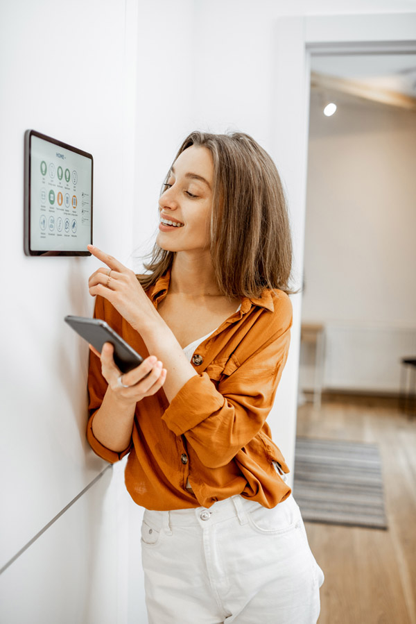 Homeowner adjusting lighting and temperature from a smart home wall panel